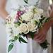 brides holding white bouquet of roses